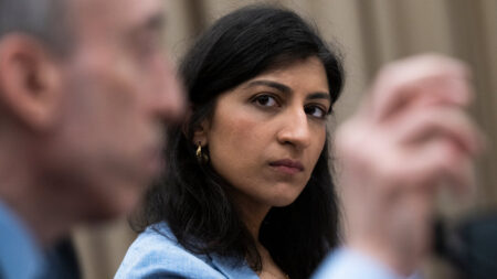 Lina Khan in primo piano mentre fissa un uomo