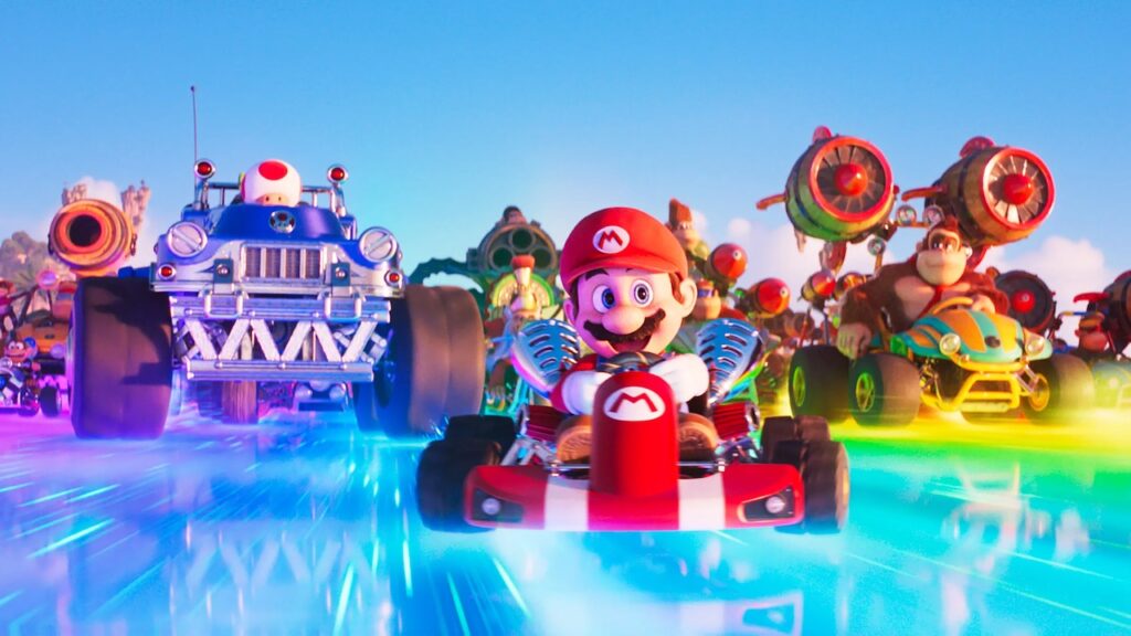 Super Mario su un Kart insieme a Donkey Kong e Toad sulla pista arcobaleno