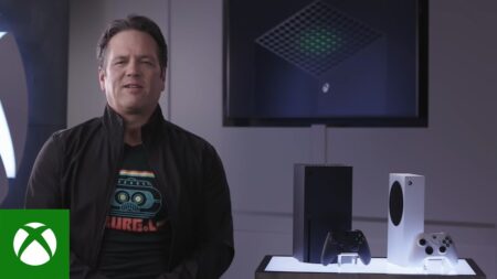 Phil Spencer con al fianco una Xbox Series X e Series S su un tavolino