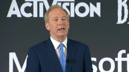 Brad Smith di Microsoft con dietro il logo di Activision Blizzard