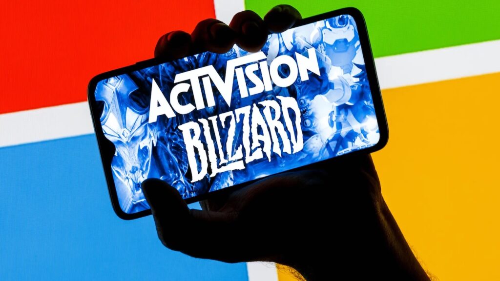 Uno smartphone con dentro il logo di Activision Blizzard e con sullo sfondo il logo di Microsoft