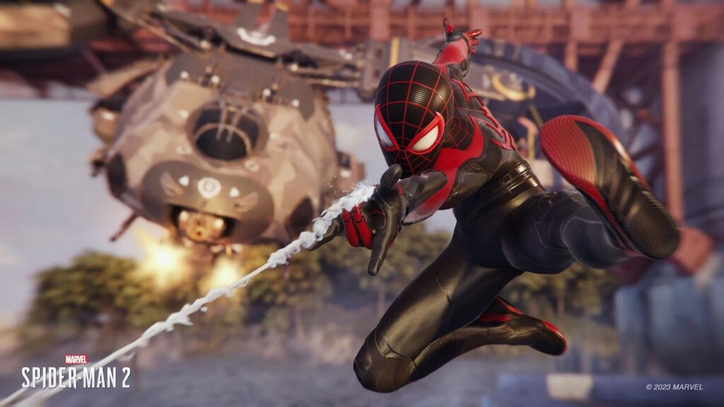 Miles Morales di Marvel's Spider-Man 2 in cielo con un elicottero che spara dietro le spalle
