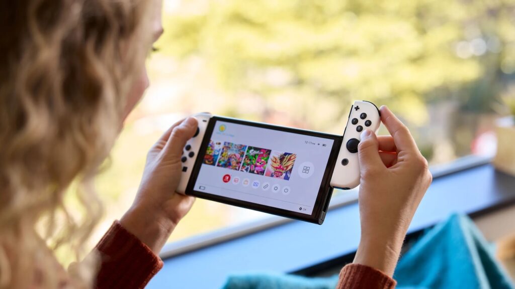 Una Nintendo Switch Modello OLED in mano ad una ragazza
