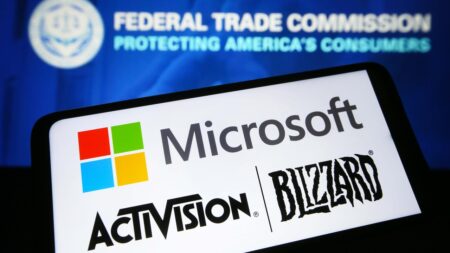 Uno smartphone con il logo di Microsoft ed Activision Blizzard e con dietro quello dell'FTC