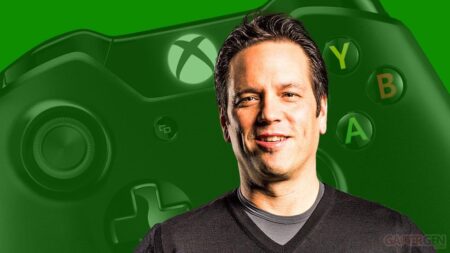 Phil Spencer con dietro un controller Xbox