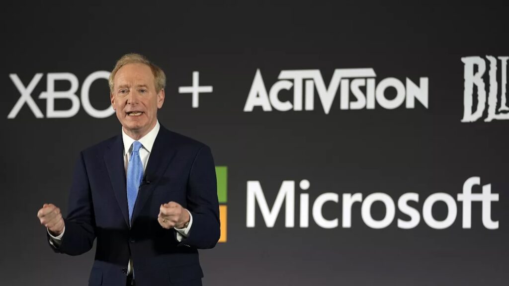 Il presidente di Microsoft Brad Smith con dietro i loghi di Activision Blizzard