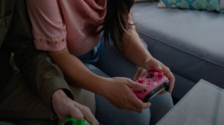 Un pad Xbox tra le mani di una giocatrice