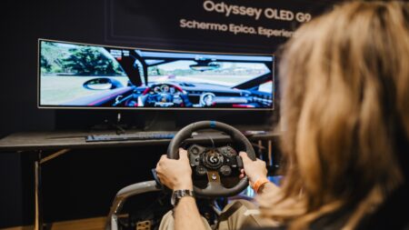 Una ragazza mentre utilizza un volante per un videogioco