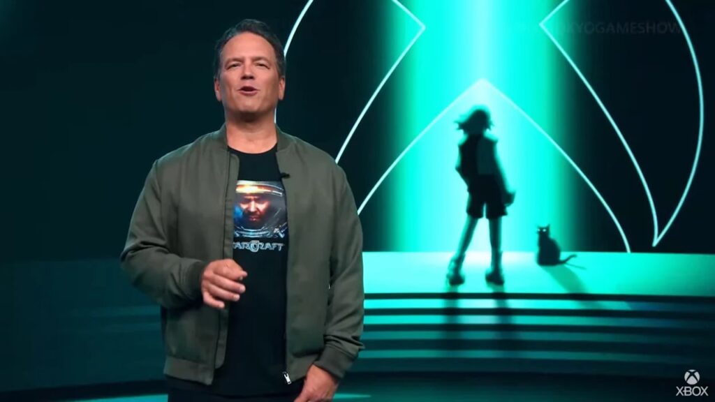 Phil Spencer con il logo di Xbox ed una ragazza ed un gattino anime sullo sfondo