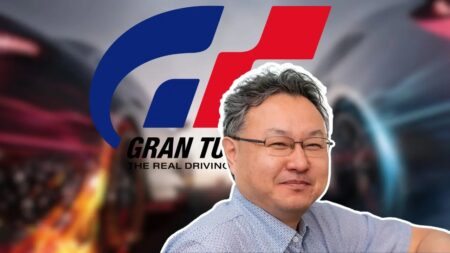 Shuhei Yoshida con dietro il logo di Gran Turismo