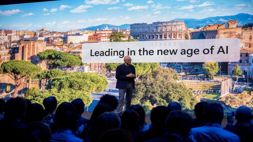 Satya Nadella con il logo di Microsoft