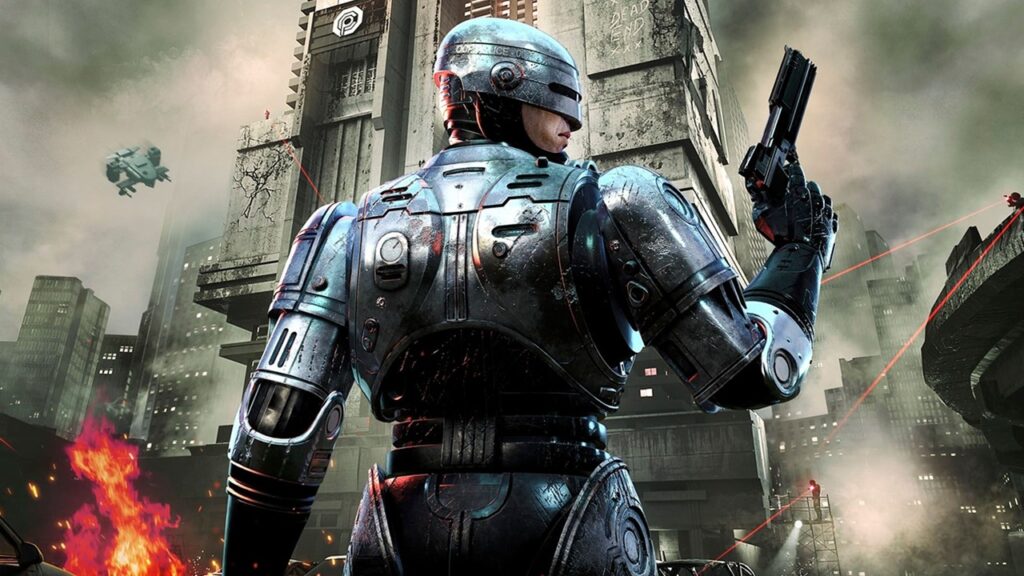 Key art di RoboCop - Unfinished Business, con RoboCop in primo piano di spalle davanti alla OmniTower