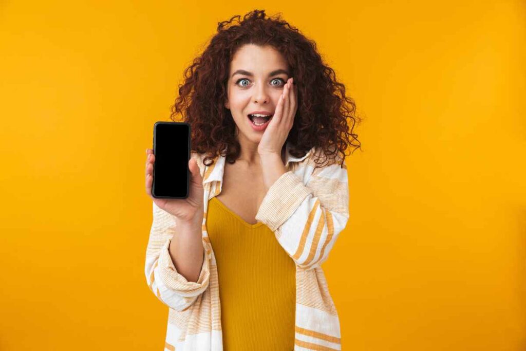 Donna sorpresa con lo smartphone in mano
