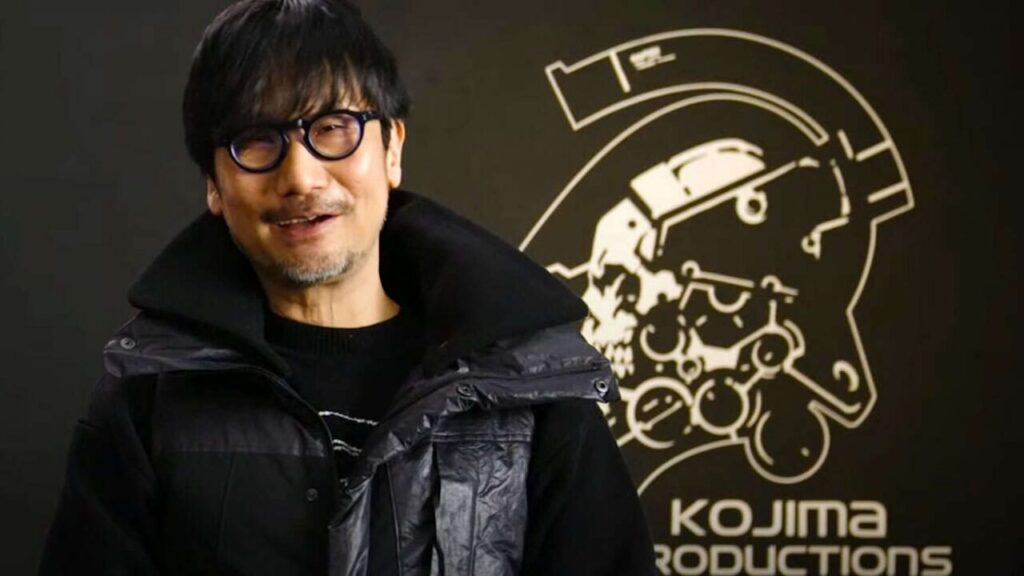 Hideo Kojima con dietro il logo di Kojima Productions