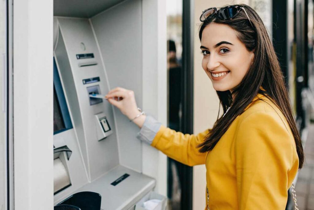 Donna infila una carta nel bancomat