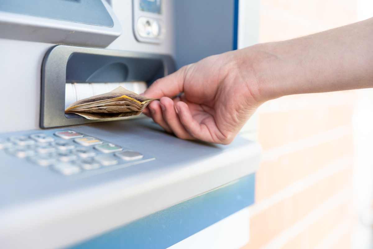 Persona raccoglie delle banconote