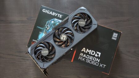 Fotografia della GPU GIGABYTE AMD Radeon RX 9060 XT GAMING OC 16G con scatola sotto di essa