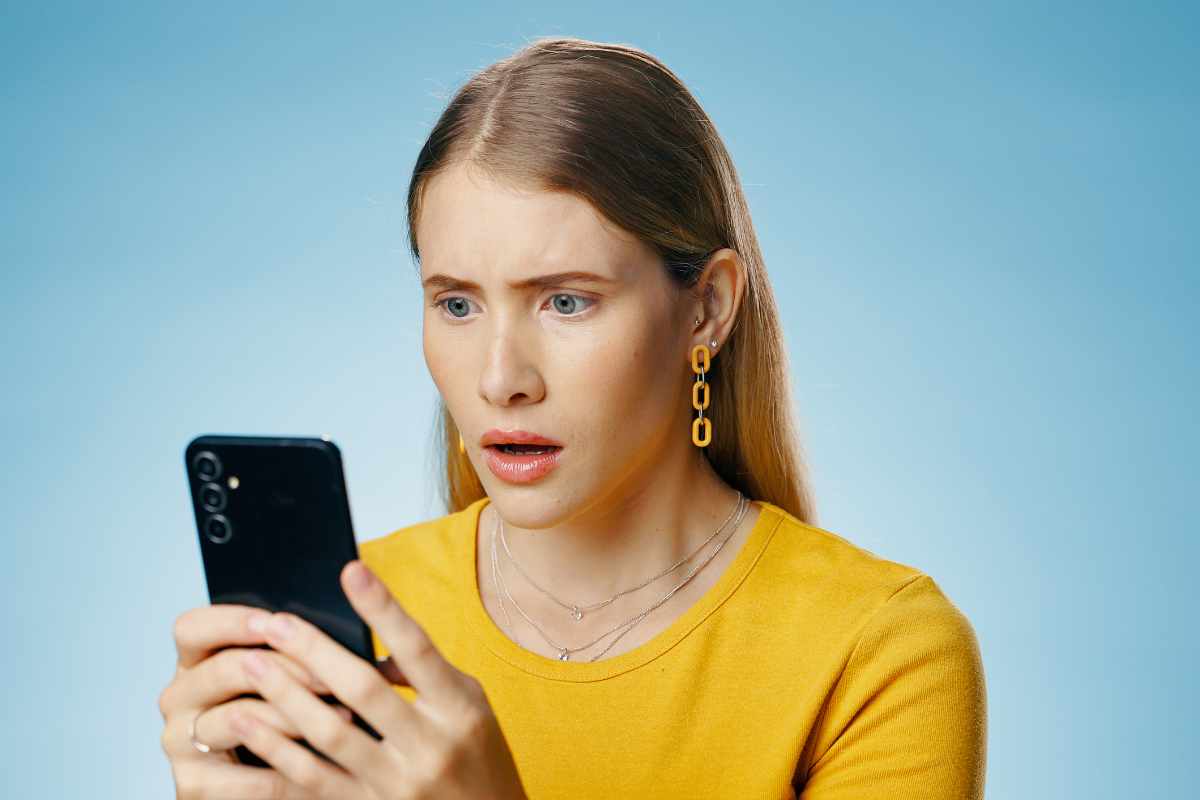 Donna preoccupata guarda lo smartphone