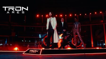 Jared Leto di TRON: Ares su un palco con lo sfondo rosso