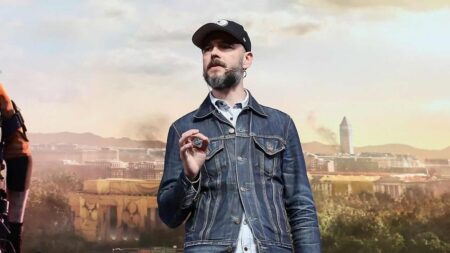 Julian Gerighty con dietro un'ambientazione di The Division