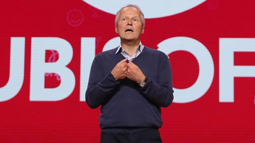 Yves Guillemot con dietro il logo di Ubisoft
