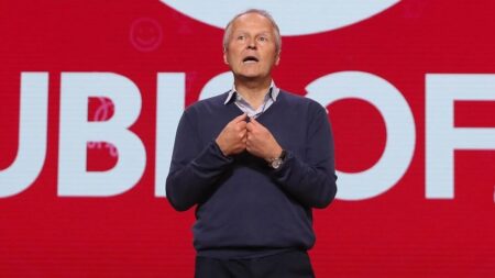 Yves Guillemot con dietro il logo di Ubisoft
