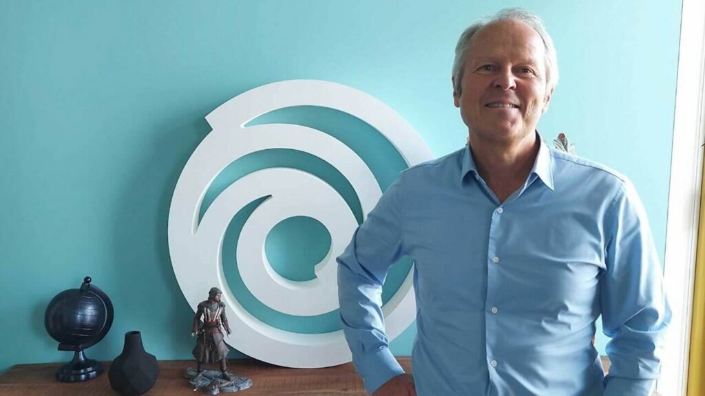 Il CEO di Ubisoft con il logo dell'azienda dietro di lui